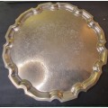 A VINTAGE ROUND SILVER PLATED SERVING TRAY SOLD AS IS