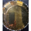 AN ANTIQUE ROUND EPNS ON BRASS SERVING TRAY SOLD AS IS