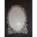 An ornate pewtal alloy oval picture frame in good condition sold as is
