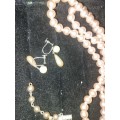 A VINTAGE COLLECTION OF SIMULATED PEARL NECKLACES AND A PAIR OF EARRINGS SOLD AS IS