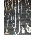 A COLLECTION OF SILVER PLATED AND STAINLESS STEEL NECKLACES WITH PENDANTS SOLD AS IS