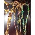 A COLLECTION OF MULTI COLOURED EXTRA LENGTH PEARL NECKLACES SOLD AS IS