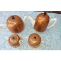 AN ANTIQUE COPPER COVERED PORCELAIN TEA SET MADE IN ENGLAND SOLD AS IS