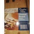 A NEVER BEEN USED GORDON BLU CHEESE BOARD AND THREE KNIVES SOLD AS IS