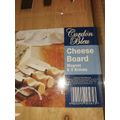 A NEVER BEEN USED GORDON BLU CHEESE BOARD AND THREE KNIVES SOLD AS IS