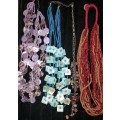 A COLLECTION OF DENSE MULTI STRAND NECKLACES SOLD AS IS