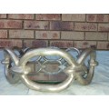 A ROUND CHAIN LINK STYLE ART DECOR SERVING TARY WITH A MIRROR BASE,