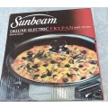 AN UNUSED SUNBEAM DELUXE ELECTRIC FRYPAN  WITH GLASS LID