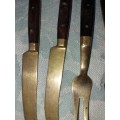 A SET OF FOUR BRASS AND WOOD KNIVES AND FORKS