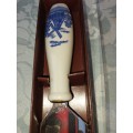 A DELF-STYLE PORCELAIN CAKE CUTTER WITH AN ORNATE WINDMILL HANDLE