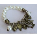 Vintage faux pearl stretch bracelet with brass tone charms