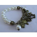 Vintage faux pearl stretch bracelet with brass tone charms