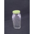Old glass storage bottle with green tin lid