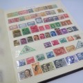 Slip in stamp album with almost 600 world stamps - Unresearched