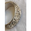 Silver Bangle with moulded relief depicting flowers,