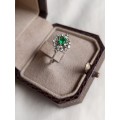 A stunning diamond and emerald cluster ring