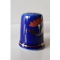 A Vintage collectors thimble. Thimble in blue glaze, painted flower in front