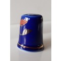 A Vintage collectors thimble. Thimble in blue glaze, painted flower in front