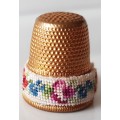 A Vintage collectors metal thimble. Thimble has small embroidered floral band