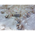 A SPARKLING SINGLE STRAND CRYSTAL NECKLACE WITH 6 SIDE DROP CRYSTALS AND A CENTRAL DROP PENDANT