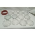 Twelve vintage Consol bottle glass lids & 10 elastic rings