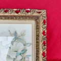 A signed watercolor painting in a decorative frame