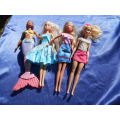 Four fashion dolls.  No markings.