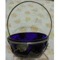 Cobalt blue glass bowl in a metal basket.