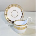 WHITE GOLD GILDED CUP AND SAUCER WITH KPM STYLE HANDLE AND UNIDENTIFIED MARK