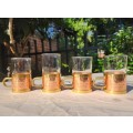 FOUR LIQUEUR GLASSES WITH COPPER AND BRASS METAL HOLDERS FEATURING A LOCK LOOP BRASS HANDLE