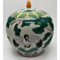 Chinese Famille Rose jar and cover decorated with storks amongst pine trees