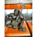 Set of three Balinese patinated bronze figures of seated musician, on wooden bases