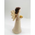 Willow Tree style wooden angel holding yellow flowers