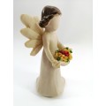 Willow Tree style wooden angel holding yellow and red flowers