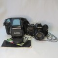 Ricoh KR-10 camera in pouch with Rikenon 1:2 50 mm lens and booklets