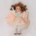 Vintage porcelain doll with peach color dress