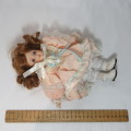 Vintage porcelain doll with peach color dress