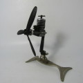 Small A-M airplane model engine on stand