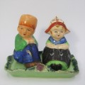 Pair of vintage Dutch boy and girl salt and pepper shakers on stand