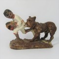 Vintage resin figurine of boy being bitten by bulldog - repaired