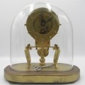 Antique brass skeleton clock with glass dome