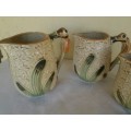 A set of three vintage bee style porcelain decorative porcelain jugs