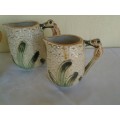 A set of three vintage bee style porcelain decorative porcelain jugs