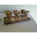 two small brass goblets on trays please note