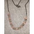 Long sliver tone costume necklace with pink crystals