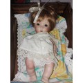 Cute full procelain baby doll in wooden  crib
