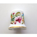 AN AVON THIMBLE SURROUNDED BY FLOWERS