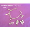 A SOLID SILVER CHARM BRACELET WITH EXTRA LARGER CHARMS