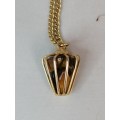 AN UNUSUAL CAGED TIGERS EYE PENDANT ON A GOLD TONE CHAIN