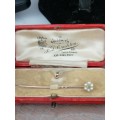 A Stunning, classy gold pin set with  a small emerald surrounded by seed pearls in it`s original box
